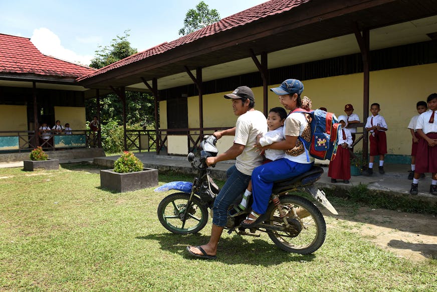 Ouders brengen Moses op brommer naar school
